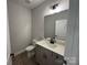 Half bath featuring single sink vanity with quartz countertop and modern light fixture at 5006 Mclaughlin Dr # 103, Waxhaw, NC 28173