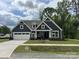 Charming new construction home featuring a well-manicured lawn and a spacious white two-car garage at 5006 Mclaughlin Dr # 103, Waxhaw, NC 28173