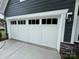 A white garage door is contrasted by gray siding and a stone foundation at 5006 Mclaughlin Dr # 103, Waxhaw, NC 28173