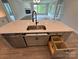 Kitchen island featuring stainless steel sink, drawer inserts and open trash bin at 5006 Mclaughlin Dr # 103, Waxhaw, NC 28173