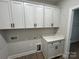 Laundry room featuring white cabinets with black hardware, quartz countertops, and wood floors at 5006 Mclaughlin Dr # 103, Waxhaw, NC 28173