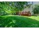 Expansive backyard showcasing a well-maintained lawn, mature trees, deck, and screened-in porch at 511 Pembroke Ln, Waxhaw, NC 28173