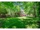 Secluded backyard featuring lush green grass, mature trees, deck, and screened in porch at 511 Pembroke Ln, Waxhaw, NC 28173