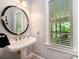 Charming bathroom features pedestal sink, stylish mirror, and natural light from the window at 511 Pembroke Ln, Waxhaw, NC 28173