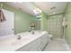 Well-lit bathroom featuring a double vanity, large mirror, and a shower with patterned curtain at 511 Pembroke Ln, Waxhaw, NC 28173