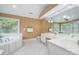 Bright bathroom with a tub, white cabinets, large mirror, and wallpaper accent at 511 Pembroke Ln, Waxhaw, NC 28173