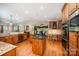 Well-lit kitchen boasts wooden cabinets, granite countertops, stainless appliances, and open dining area at 511 Pembroke Ln, Waxhaw, NC 28173