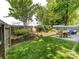 Fenced backyard with green grass, mulched garden beds, and outdoor seating at 5304 Silabert Ave, Charlotte, NC 28205