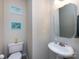 Powder room with pedestal sink, tiled floors and decorative artwork giving the room a clean modern look at 5304 Silabert Ave, Charlotte, NC 28205