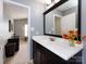 Bathroom vanity with a large mirror, dark cabinetry and view to bright adjacent bedroom at 5304 Silabert Ave, Charlotte, NC 28205