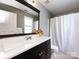 Full bathroom with a large mirror, white vanity top, and shower with a curtain at 5304 Silabert Ave, Charlotte, NC 28205