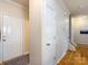 Hallway with neutral paint, light hardwood floors and multiple doors leading to various rooms in the home at 5304 Silabert Ave, Charlotte, NC 28205