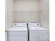 Functional laundry room with washer, dryer, and overhead shelving at 5304 Silabert Ave, Charlotte, NC 28205