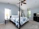 Bright main bedroom with a four-poster bed, ceiling fan, and light blue accent walls at 5304 Silabert Ave, Charlotte, NC 28205
