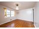 This bedroom features hardwood floors, a window with curtains, and an ornate ceiling fixture at 542 9Th Nw St, Hickory, NC 28601