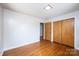 Bedroom with hardwood floors, access to hallway, closet, and natural lighting from ceiling and window at 542 9Th Nw St, Hickory, NC 28601
