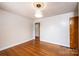 A bedroom with hardwood floors, a ceiling fixture, and a view to the hallway and another room at 542 9Th Nw St, Hickory, NC 28601