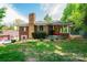 Charming brick home featuring a stone chimney, well-manicured landscaping, and a vibrant red front door at 542 9Th Nw St, Hickory, NC 28601
