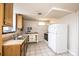 Kitchen with wood cabinets, stainless steel sink, white appliances, and tile flooring at 542 9Th Nw St, Hickory, NC 28601