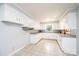 Well-lit kitchen featuring white cabinetry, tiled floors, and modern fixtures at 542 9Th Nw St, Hickory, NC 28601