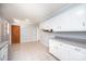 Open kitchen with white cabinets, tile floors, and view to the hallway and the back yard at 542 9Th Nw St, Hickory, NC 28601