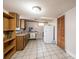 A full kitchen with wood cabinets, a white refrigerator, and tile flooring at 542 9Th Nw St, Hickory, NC 28601