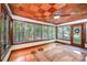 Bright sunroom with hardwood floors, a unique checkered ceiling, and lots of windows providing an abundance of natural light at 542 9Th Nw St, Hickory, NC 28601