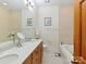 Bright bathroom featuring double sinks, soaking tub, and neutral tile at 6133 Wakehurst Rd, Charlotte, NC 28226