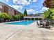 Large community pool with lounge chairs and tables, surrounded by manicured landscaping and multi-story homes at 6133 Wakehurst Rd, Charlotte, NC 28226