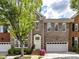 Charming brick townhome featuring manicured landscaping, attached garage, and inviting front entrance with colorful flowers at 6133 Wakehurst Rd, Charlotte, NC 28226