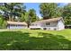 Spacious backyard with green grass, mature trees, a deck, and detached building at 7141 Pitchfork Ln, Mint Hill, NC 28227
