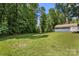 Large, grassy backyard with mature trees and detached building at 7141 Pitchfork Ln, Mint Hill, NC 28227