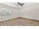 This bedroom has a ceiling fan, light neutral walls, updated flooring and a window to let in the light at 7141 Pitchfork Ln, Mint Hill, NC 28227