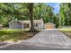 Charming home with a long driveway and a detached garage surrounded by a well-manicured lawn at 7141 Pitchfork Ln, Mint Hill, NC 28227