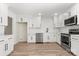 Bright kitchen features white cabinets, stainless steel appliances, and wood-look flooring at 7141 Pitchfork Ln, Mint Hill, NC 28227