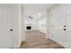Open-concept living room with hardwood floors, white brick fireplace, and natural light at 7141 Pitchfork Ln, Mint Hill, NC 28227