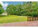 View of spacious backyard from deck, featuring lush green lawn and mature trees at 759 Victory Gallop Ave, Clover, SC 29710