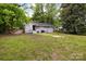 The backyard has green grass, a patio area, and mature trees for shade at 816 Echo Glen Rd, Charlotte, NC 28213
