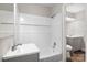 Bathroom features white tiled tub surround, gray vanity, tile flooring, and updated fixtures at 816 Echo Glen Rd, Charlotte, NC 28213