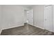 Simple bedroom with neutral light gray walls, gray laminate flooring, and white doors with modern handles at 816 Echo Glen Rd, Charlotte, NC 28213