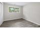 Cozy bedroom with gray vinyl flooring, light gray walls, and a window offering ample natural light at 816 Echo Glen Rd, Charlotte, NC 28213
