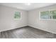 Bright bedroom with neutral walls, gray laminate floors, overhead lighting, and natural light from windows at 816 Echo Glen Rd, Charlotte, NC 28213