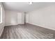 Spacious living room featuring modern light gray walls, base molding, and durable gray wood-look vinyl flooring at 816 Echo Glen Rd, Charlotte, NC 28213