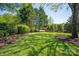 Lush backyard featuring a well-manicured lawn, mature trees, and manicured garden beds at 9217 Rock Water Ct, Waxhaw, NC 28173