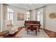 Elegant sitting room with hardwood floors, arched windows, a piano, and neutral decor at 9217 Rock Water Ct, Waxhaw, NC 28173