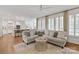 Bright, open living room with hardwood floors, a neutral sofa, and a view into the modern kitchen at 9217 Rock Water Ct, Waxhaw, NC 28173