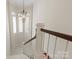Staircase landing with an ornate chandelier and a bay window for natural light at 9217 Rock Water Ct, Waxhaw, NC 28173