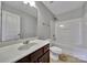 Bright bathroom featuring a single vanity, large mirror, and tub with shower at 9862 Walkers Glen Nw Dr, Concord, NC 28027