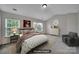 This staged bedroom includes large windows, a sitting area, and neutral color scheme at 9862 Walkers Glen Nw Dr, Concord, NC 28027
