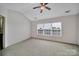 The bedroom has a large window, fan, and neutral carpet at 9862 Walkers Glen Nw Dr, Concord, NC 28027